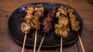 Domuz şiş, sonra ızgara. Yakitori, İzakaya restoranında popüler bir Japon yemeğidir. Japon şişi yemek parçalarını bir arada tutmak için kullanılan bir tahta çubuktur..