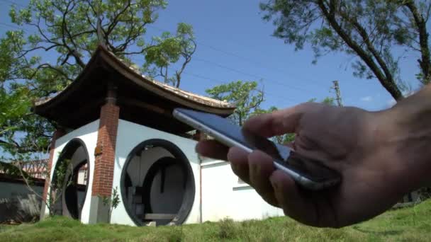 Man Bekijk Zijn Telefoon Schitterende Chinese Tuinontwerpen Met Traditionele Architectuur — Stockvideo