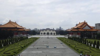 Tayvan 'ın Taipei şehrinde güneşli bir günde Ulusal Müzik Salonu ve Chiang Kai Shek Anma Salonu' nun giriş kapısında yürüyen insanların görüntüsü.