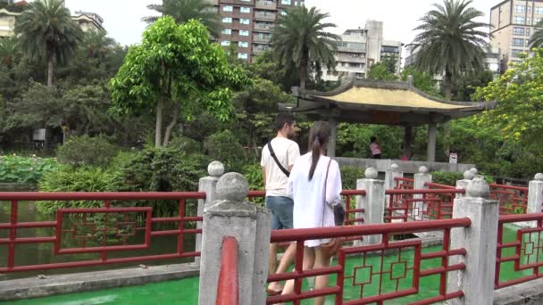 2015年5月22日台湾 台北市 4K夫婦が台湾 台北市の孫文記念館で鄭山公園の湖のパビリオンと橋の上を歩くアジアの観光客 — ストック動画