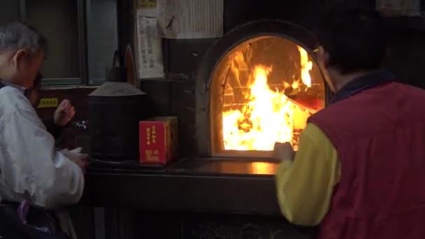 3月2016 4Kアジアの寺院でジョス紙を焼く男 幽霊のお金を焼く故人の精神のための先祖の名誉の伝統です死後の良いものがダン — ストック動画