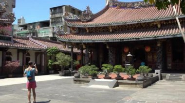 Taipei, Tayvan-12 Eylül 2017: 4K Turist mavi gökyüzü ile Dalongdong Baoan Tapınağı 'nın merkez salonunda akıllı telefonla fotoğraf çekiyor. Taipei Baoan Tapınağı Tayvan-Dan 'da güzel bir ibadethane.