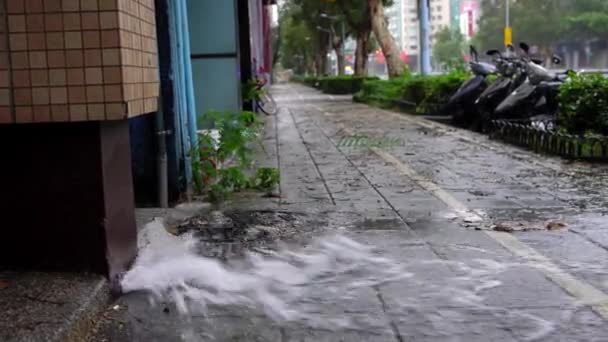 台北市の台風デーで警察車両の背景を持つパイプ水の4K爆発 路上での漏水事故 道路上の水の流れ — ストック動画