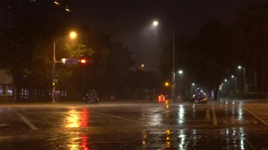 Taipei, Tayvan-29 Temmuz 2017: Ağır çekim rüzgar ve Tayfun Nesat 'ın yağmuru, insanlar motosiklet ve araba kullanıyor. Kasırganın güçlü olduğu Taipei Caddesi. Trafik Asyalı yol gecesi Tayvan-Dan