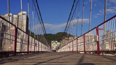Taipei, Tayvan-28 Mayıs 2015: Bitan Askı Köprüsü 'nde yürüyen 4 bin insan güneşli ve mavi gökyüzüyle güzel bir yaz gününde. New Taipei şehrinin Xindian bölgesindeki ünlü eğlence merkezi, Tayvan-Dan