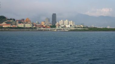 Tamsui nehrinin 4K peyzajı ve Taipei 'deki karşı nehir kıyısında binalar. Sakin bulutlu hava. - Dan.