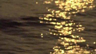 Güneş hafifçe dalgalanan okyanus yüzeyinde parıldıyor, güneş ışığı okyanusun sakin suyuna yansıyor 4k. Tamshui 'nin Günbatımı, Tayvan-Dan