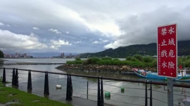 Kışın yağmurlu bir gününde, Tamsui rıhtımındaki su nehrindeki 4K peyzaj. Tayvan-Dan
