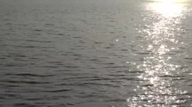 Güneş hafifçe dalgalanan okyanus yüzeyinde parıldıyor, güneş ışığı okyanusun sakin suyuna yansıyor 4k. Tamshui 'nin Günbatımı, Tayvan-Dan