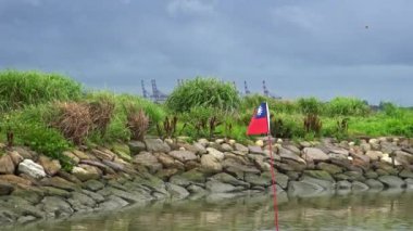 Tamsui rıhtımındaki su nehrinde Taiwan bayrağı taşıyan eski küçük teknenin 4K peyzajı.