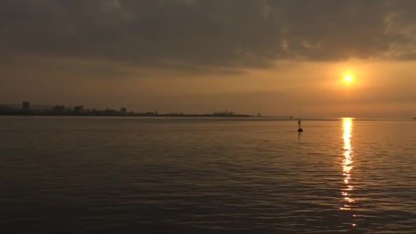 4K一个浮标漂浮在海岸附近 阳光在微微荡漾的海面上闪闪发光 阳光反射在平静的海面上 塔木水日落 台湾丹 — 图库视频影像