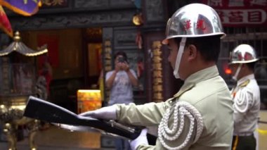 Taipei, Tayvan 19 Haziran 2018: Tayvan 'da bir Matsu tapınağı önünde Çin tanrılarının geçit törenine katılan ağır çekim askeri. Askeri üniformayla sokak ortasında tören düzenleniyor.