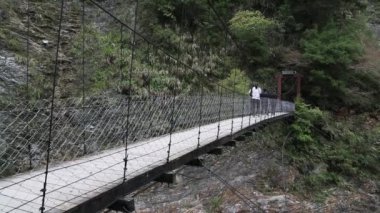 Taroko, Tayvan-28 Şubat 2014: İnsanlar Taroko Park-Dan 'da Suspension Köprüsü Şelalesi' ni geçiyor.