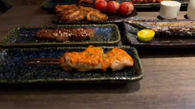 4K, akşam yemeğinde ızgarada pişirilmiş lezzetli geleneksel şiş seti. Restoranda popüler Japon yemekleri. Aperatif Japon şiş tabağı ahşap masada. - Dan.