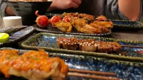 夕食のためにグリルおいしい伝統的な串焼きのセット レストランで人気の日本料理 木製のテーブルの上に日本の串プレートを食欲をそそる — ストック動画