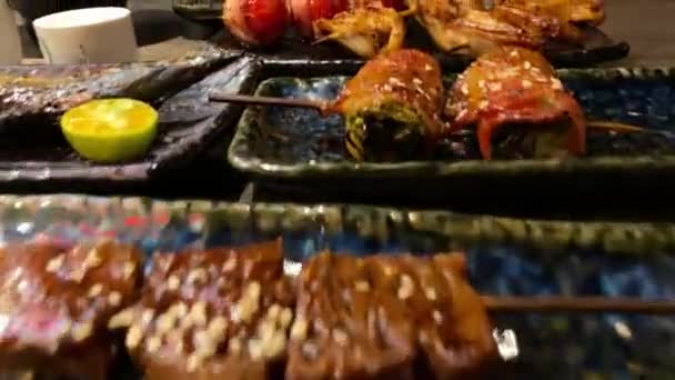 夕食のためにグリルおいしい伝統的な串焼きのセット レストランで人気の日本料理 木製のテーブルの上に日本の串プレートを食欲をそそる — ストック動画