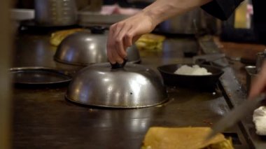Yavaş çekimde tavada kızartılmış guotie. Profesyonel bir aşçı, ızgarada kızartılmış hamur köftesi pişiriyor. Japon lezzetli yemekleri. Adam bir restoranda yemek pişiriyor, geleneksel bir mutfakta çalışıyor.
