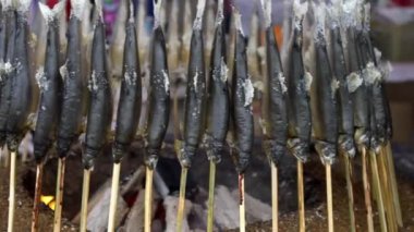 Kömürün yanında ızgara balık. Tedarikçi Japonya 'nın pazar caddesinde ünlü bir yemek pişiriyor. İnsanlar popüler ve geleneksel Japon usulü kömür mangalında mangal kömürü pişirdiler. - Dan.