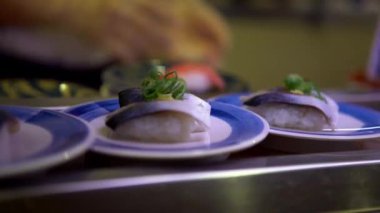 4K, Japonya 'da bir restoranda taşınan taşıma bandı üzerine sushi. Geleneksel Kaitenzushi Japon yemekleri. Shushi Go Round Asya 'da yaygın bir fast food çeşididir, suşi treni olarak da bilinir.
