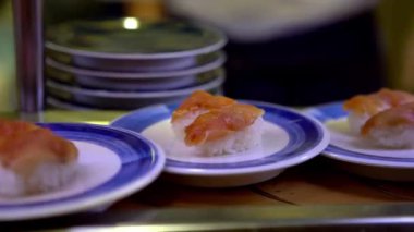 4K, Japonya 'da bir restoranda taşınan taşıma bandı üzerine sushi. Geleneksel Kaitenzushi Japon yemekleri. Shushi Go Round Asya 'da yaygın bir fast food çeşididir, suşi treni olarak da bilinir.