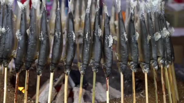 スティック上の石炭の横に魚のグリル 日本の市場通りで有名な食べ物を調理するベンダー 炭の炎でバーベキューを焼く 人気のある日本の伝統的なスタイルを調理しました — ストック動画