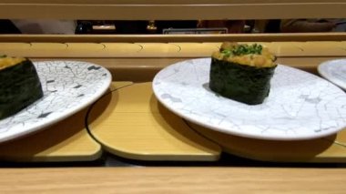 4K, Japonya 'da bir restoranda taşınan taşıma bandı üzerine sushi. Geleneksel Kaitenzushi Japon yemekleri. Shushi Go Round Asya 'da yaygın bir fast food çeşididir, suşi treni olarak da bilinir.