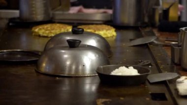 Teppanyaki sırasında ağır çekimde ızgara tava. Japon şef restoranda yemek ve ızgara yapıyor. Japonya 'da turistler için lezzetli ve popüler yemekler