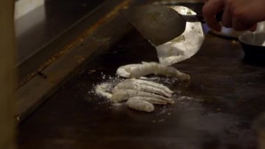 Teppanyaki ızgarasında yavaş hareket eden ızgara karides. Japon karides stili hazırlanmış. Açık bir lokanta mutfağında karides pişiren özel şef. Japonya 'da geleneksel et lokantası.