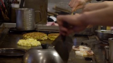 Teppanyaki sırasında ağır çekimde ızgara tava. Japon şef restoranda yemek ve ızgara yapıyor. Japonya 'da turistler için lezzetli ve popüler yemekler