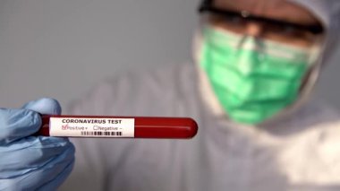 4K, koruyucu kıyafetli erkek bilim adamı ve laboratuvarda COVID-19 testi pozitif. Coronavirus enfeksiyonu teşhisi için kan testi. Wuhan 'dan 2019 numaralı hastalık. Bulaşıcı bulaşıcı konsept - Dan