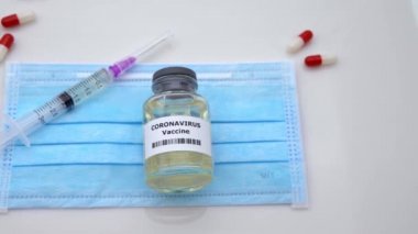 4K, Covid19 numune aşısı ve koruyucu cerrahi maskeye şırınga. Coronavirus 2019-nCov konsepti için önleyici ilaçlar. Corona virüsü tehlikesi ve halk sağlığı riski hastalığı - Dan