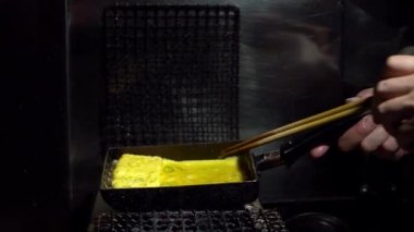 Tamagoyaki omleti, Tokyo şehir merkezindeki bir markette metal tavalar içinde. İzakaya restoranında popüler Japon sokak yemekleri.