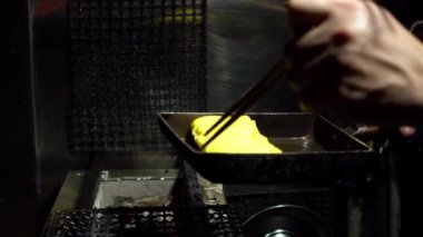Tokyo şehir merkezindeki bir markette metal tavalarda Tamagoyaki omletlerinin Yavaş Hareketi. İzakaya restoranında popüler Japon sokak yemekleri.