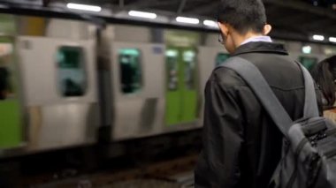 Tokyo, Japonya-04 Nisan 2020: 4K Asyalı kadın aktif metroda akıllı telefon kullanıyor. Sosyal ağları kontrol eder ve telefon cihazında yapılan metinleri yazar. Japon tren istasyonu Dan 'de teknoloji telefonu kullanan yolcu.