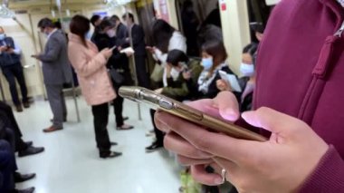 Taipei, Tayvan-01 Nisan 2020: 4K, Asyalı kadın akıllı telefon kullanıyor ve 2019-NCoV bulaşabilir enfeksiyonuna karşı maske takıyor. Coronavirus-Dan 'in korunması için maskeler kullanılıyor.