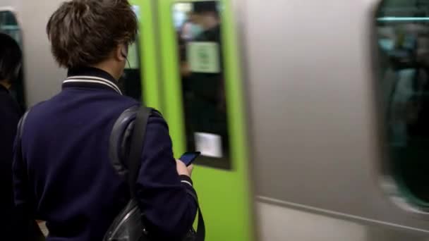 2020年4月4日 在地铁里的亚洲女游客手持智能手机 乘客在地铁中使用技术智能电话旅行 生活方式和交通 — 图库视频影像