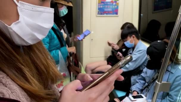 2020年3月15日 アジアの女性がスマートフォンを使用し 地下鉄での2019 Ncvの感染症に対するマスクを着用しています コロナウイルスダンの保護のためのマスクの使用 — ストック動画