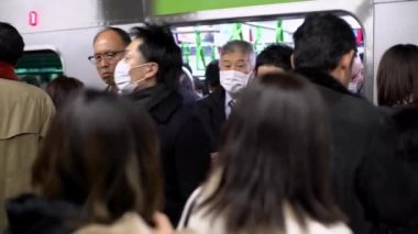Tokyo, Japonya-04 Şubat 2017: 4K, Asyalılar metroda yoğun saatlerde bulaşıcı hastalıklara karşı koruyucu maske takıyorlar. Coronavirus koruması - Dan