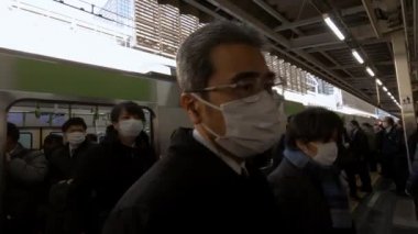 Tokyo, Japonya-04 Şubat 2017: 4K, Asyalılar metroda yoğun saatlerde bulaşıcı hastalıklara karşı koruyucu maske takıyorlar. Coronavirus koruması - Dan