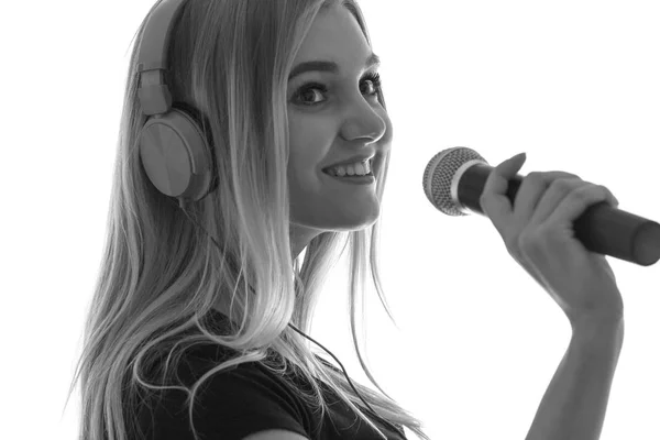 Silhouett μια νεαρή γυναίκα στα ακουστικά και με μικρόφωνο — Φωτογραφία Αρχείου
