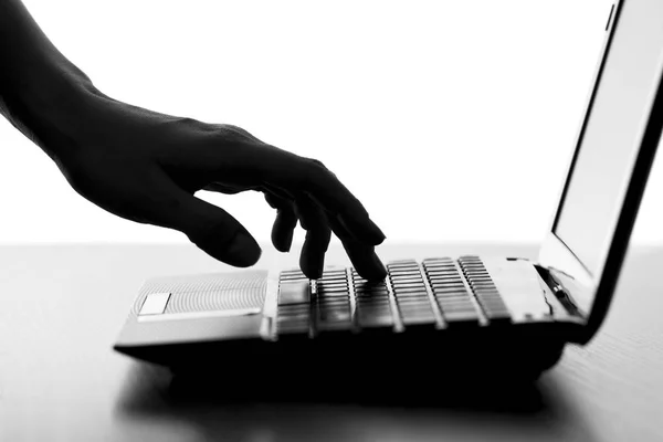 Silhouette of a female hand typing on the keyboard — Stock Photo, Image