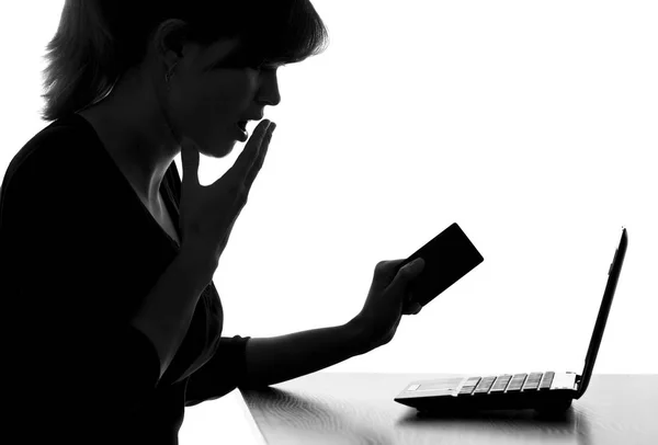 Ritratto di una donna con una carta di credito spaventata guardando il monitor di netbook — Foto Stock