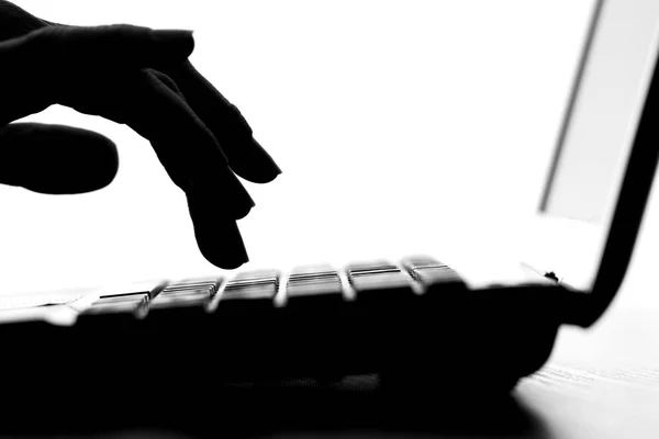 Silhouette di una mano femminile che digita sulla tastiera — Foto Stock