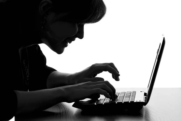 Silhouette of a hacker typing on the keyboard of laptop — Stock Photo, Image