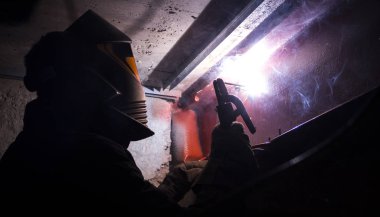 Kaynakçı koruyucu maske içinde metal ile çalışır