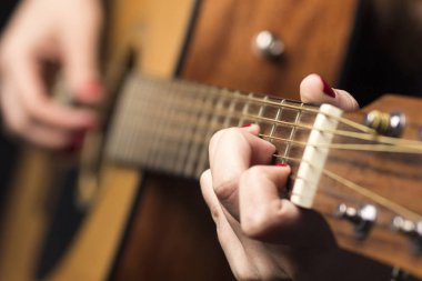 Genç kadın parmakları Gitar telleri ile sabitlenmiş