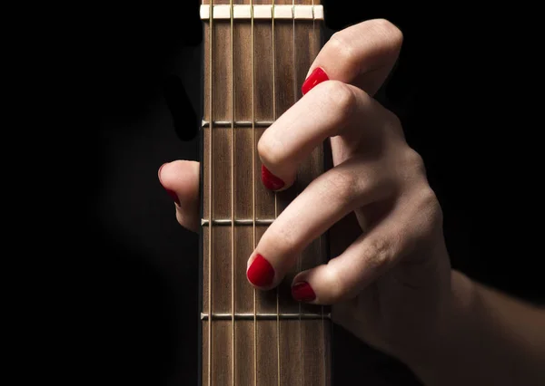 Mano femenina agarra las cuerdas de la guitarra — Foto de Stock