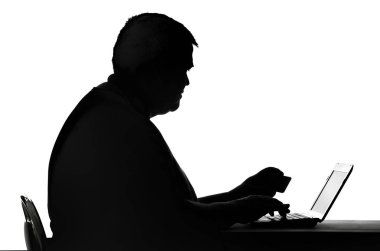 bir bilgisayarınızda bir şifre kartına yazarak bir adam silüeti