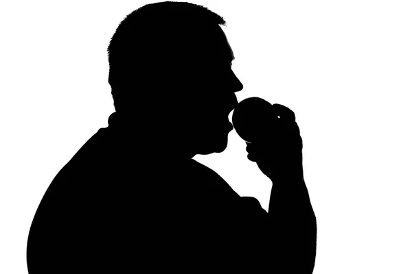 Silhouette of a man with biting fruit — Stock Photo, Image