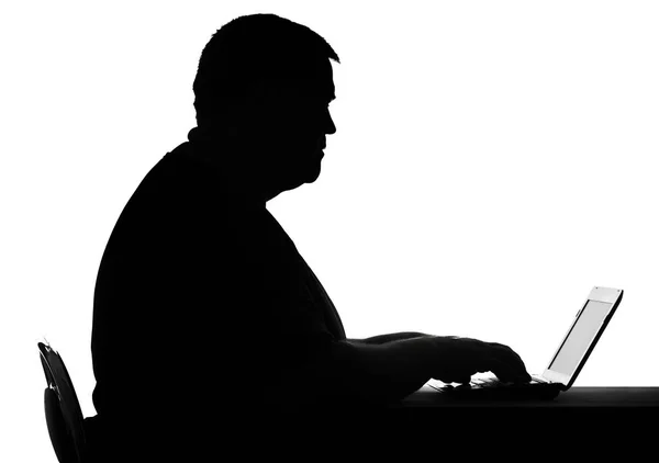 Silhouette of a man lead inactive lifestyle, working on laptop — Stock Photo, Image